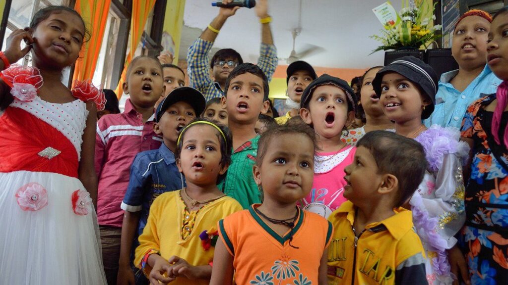 Children in treatment singing together at a celebration